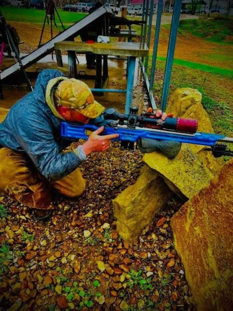 Shooter using an angled barricade to practice tactical rifle positioning at Recon By Fire range