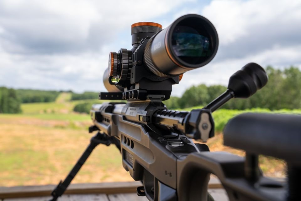 Close-up of long-range rifle with mounted scope overlooking open shooting lanes at Recon By Fire Precision Range in Oklahoma
